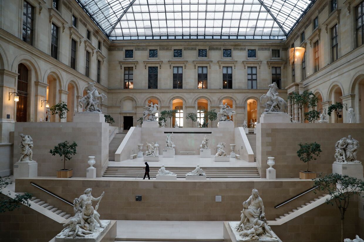 Uma zona no interior do Museu do Louvre, agora fechado temporariamente devido à pandemia. O museu, que durante o ano de 2019, recebeu 9,6 milhões de visistantes, está agora vazio e pode apenas ser visto um funcionário a tratar da limpeza do espaço.