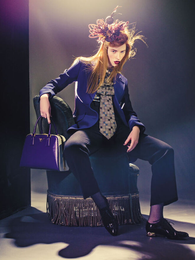 Meias de rede, ?4,80, Calzedónia. Sapatos em pele envernizada, Valentino na Stivali (preço sob consulta). Carteira em pele, ?2290, Prada. Colar em metal e strass, Valentino na Stivali (preço sob consulta). Toucado com penas e rede, ?79, Luís Stoffel