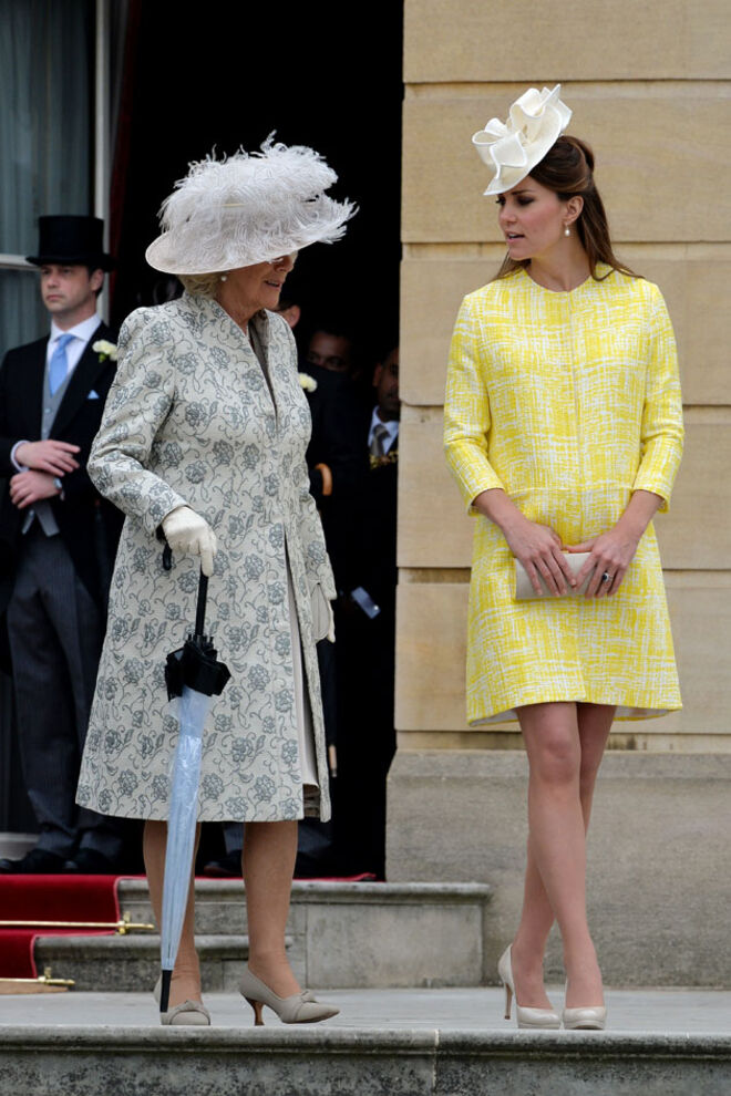Com a duquesa da Cornualha numa Garden Party oferecida pela rainha Isabel II no Palácio de Buckingham. O casaco é da autoria da designer Emília Wickstead.