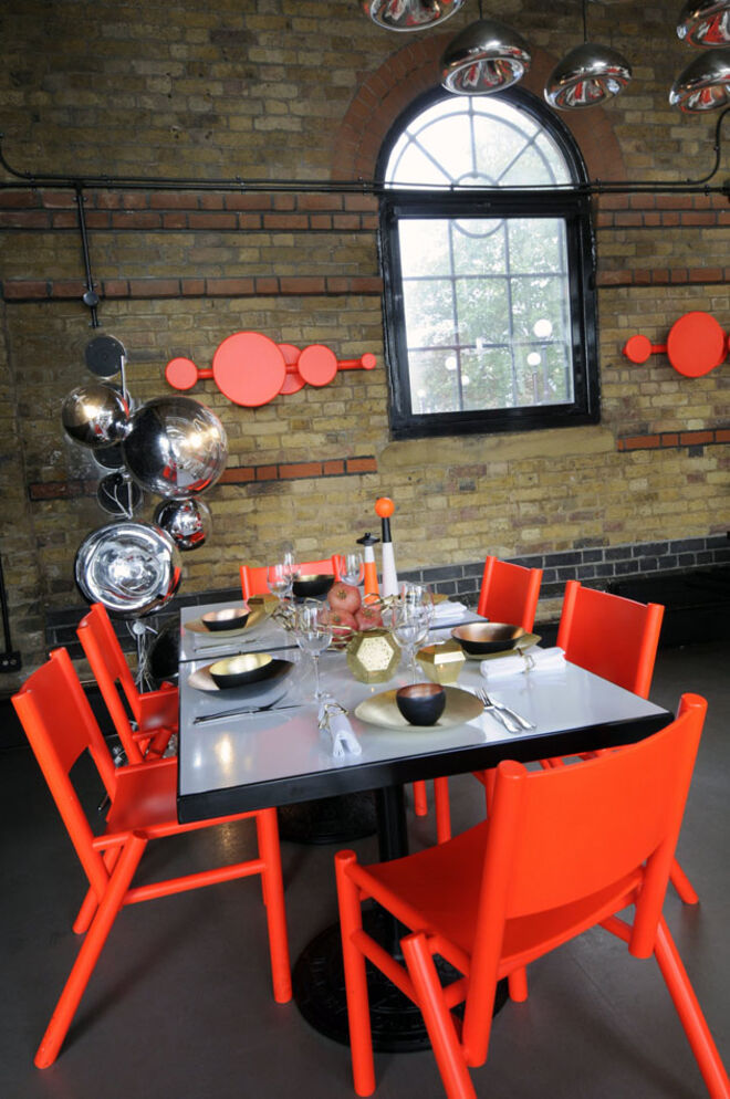 A mesa inspirada em Tom Dixon, que se estreou como baixista do grupo Funkapolitan, no fim dos anos 70. Ocasião de mostrar as suas novas coleções de arte da mesa que misturam cobre, aço e latão. Cadeiras Peg e Lustre Void. Ao fundo, luminária Mirror Ball e cabides Peg, de best of.