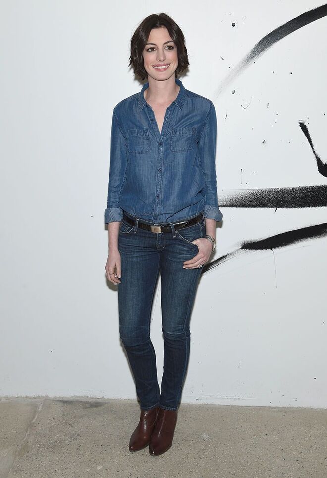 Ao jeito cowgirl de Anne Hathaway, num conjunto em ganga total e botins castanhos.