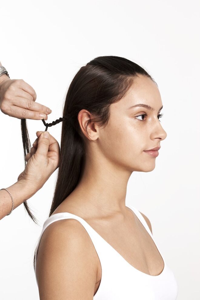 7. Continue a enrolar o rabo-de-cavalo até ao fim, junte as duas partes e prenda a ponta e faça uma nova trança em corda de um lado da cabeça. 