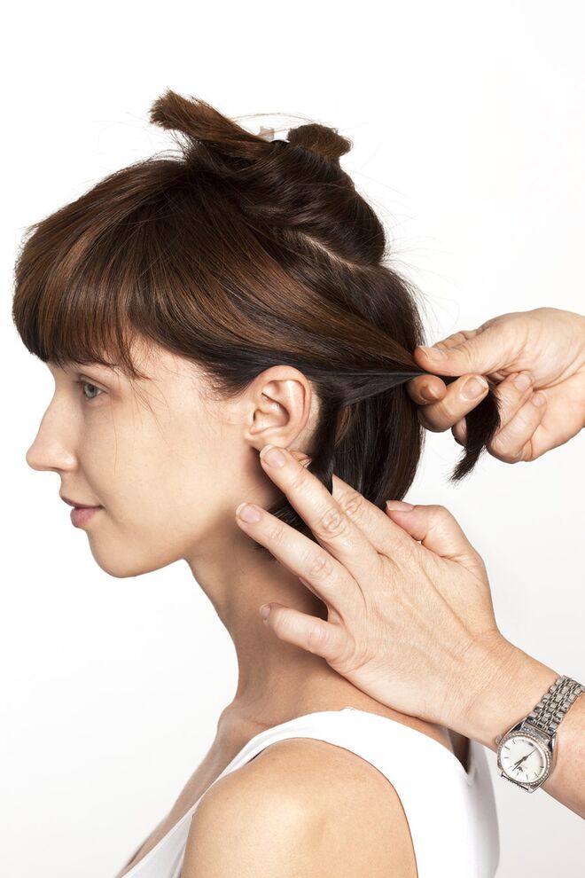 2. Separe uma madeixa de cabelo num dos lados da cabeça e enrole-a até ao meio da cabeça. 