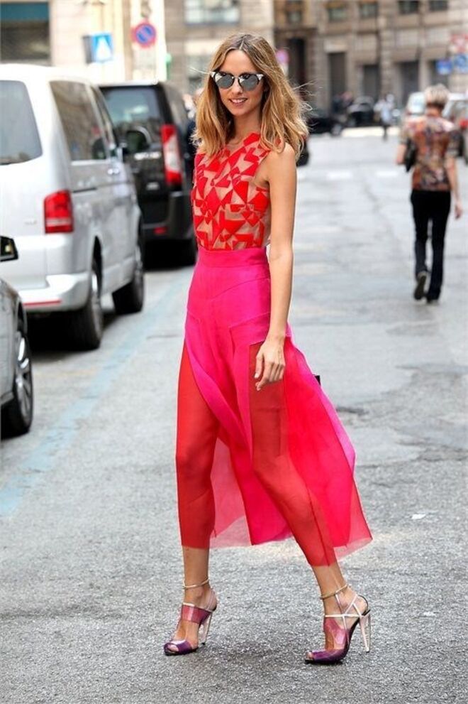 Com uma saia semi-transparente e um top com padrão assimétrico.