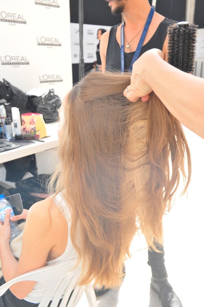 1.	Pentear o cabelo todo para trás, controlando com pinças as zonas laterais e fixando-as com um pouco de Fix Design. 