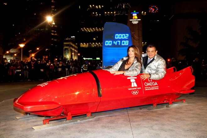 2010: Cindy visita Vancouver e Whistler durante os Jogos Olímpicos de Inverno, enquanto orgulhosamente pousa num bobsleigh juntamente com o Presidente da OMEGA Stephen Urquhart.