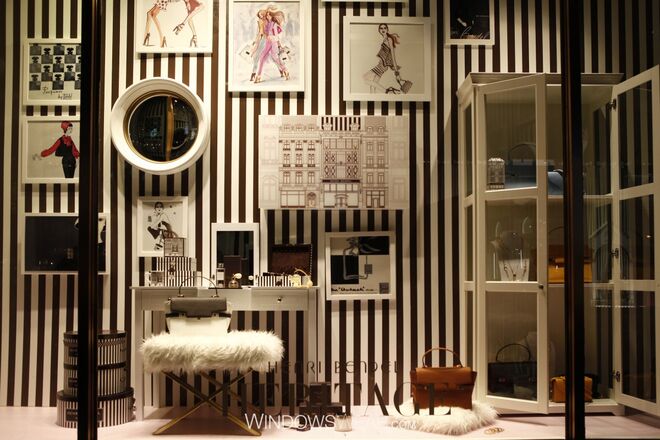 Melhor Herança | Henri Bendel  - As míticas riscas castanhas e brancas da Henri Bendel são sinónimo da herança da marca e esta é honrada nesta icónica montra/vitrine. Parte integral desta tradição são as clássicas ilustrações das meninas de Izak Zenou, cuja parceria com Henri Bendel dura há já 20 anos.