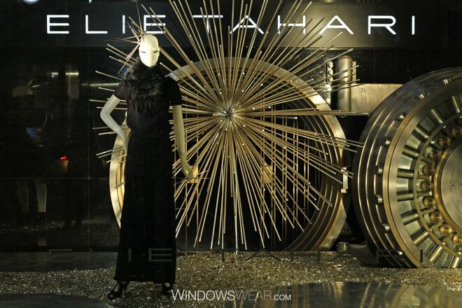   Dourado | Elie Tahari  - Elie Tahari faz uma abordagem elegante ao toque do Rei Midas nesta montra/vitrine cintilante. Apresentando bonitas órbitas metálicas e manequins com longos cílios decorados com “coroas” douradas, esta montra/vitrine simplesmente deslumbra.