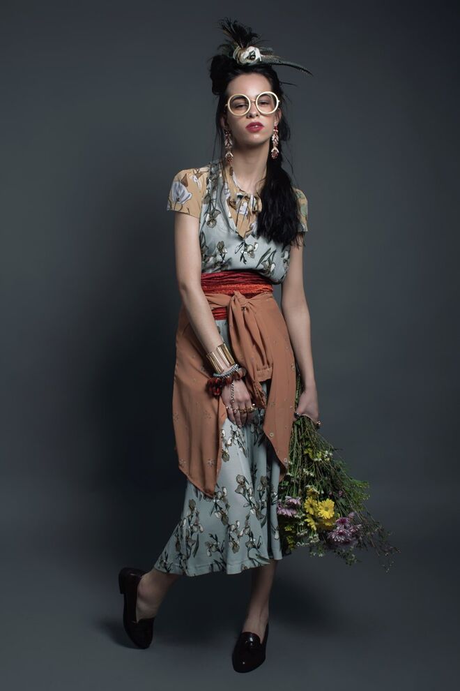 COUNTRYSIDE DREAM | Stylist: Beatriz Pacheco Modelo: Bárbara Marinho (L'agence) | Camisa à cintura, da produção; jumpsuit, Zara; camisa, Prada; lenço, acessório de cabeça, óculos, pulseira e anéis, tudo da produção; brincos, H&M; colar com medalhas usado como pulseira, Parfois; sapatos, Lefties; flores, da produção.