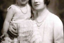 Isabel II ao colo da mãe