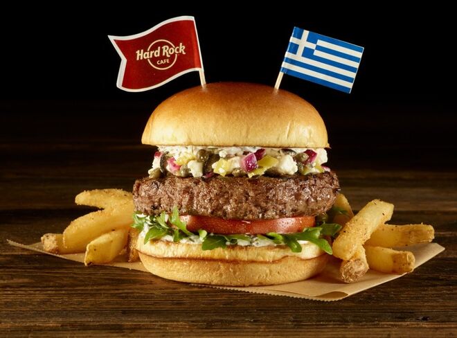 Greek - Atenas, Grécia (hambúrguer acompanhado de rúcula, tomate e uma deliciosa combinação de queijo feta, alcaparras, azeitonas pretas, pimentas verdes e cebola. Servido com batatas fritas e molho tzatziki).