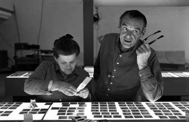 The World of Charles and Ray Eames. Charles and Ray Eames selecting slides. © Eames Office LLC