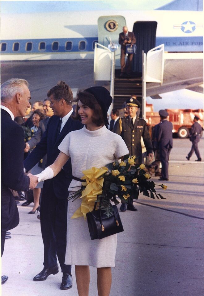 John e Jackie Kennedy a chegar ao Texas em novembro de 1963. A primeira-dama usa um chapéu pillbox e luvas, dois dos seus acessórios preferidos no guarda-roupa oficial.