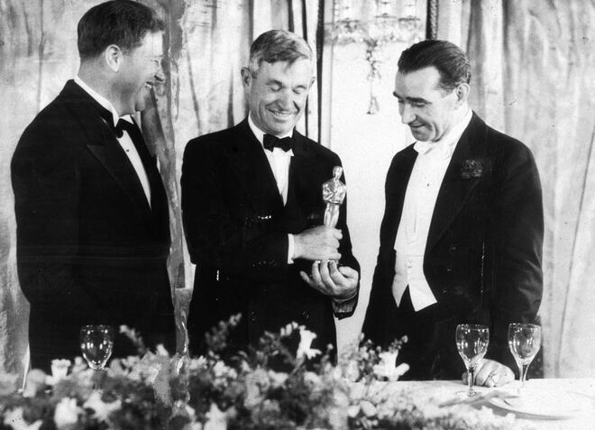 1934 | O apresentador Will Rogers com dois vencedores: Franklin Hansen (melhor banda sonora) e Frank Lloyd (melhor diretor)