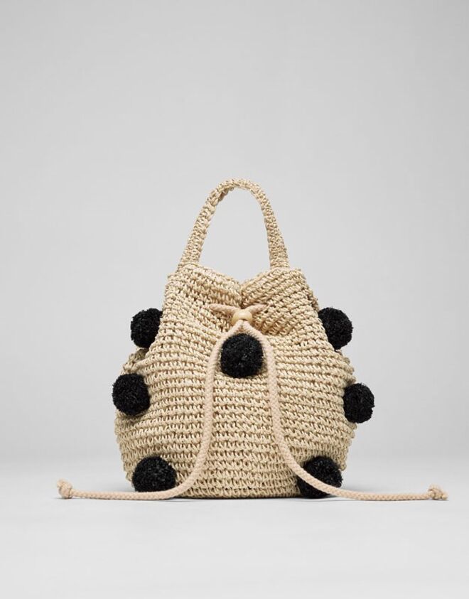 Saca de ráfia com pompons, €17,99, Pull & Bear