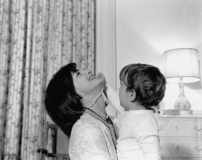 Novembro, 1962 | A Primeira Dama Jacqueline Kennedy a brincar com o filho, John F. Kennedy, Jr., na Casa Branca, em Washington, D.C.