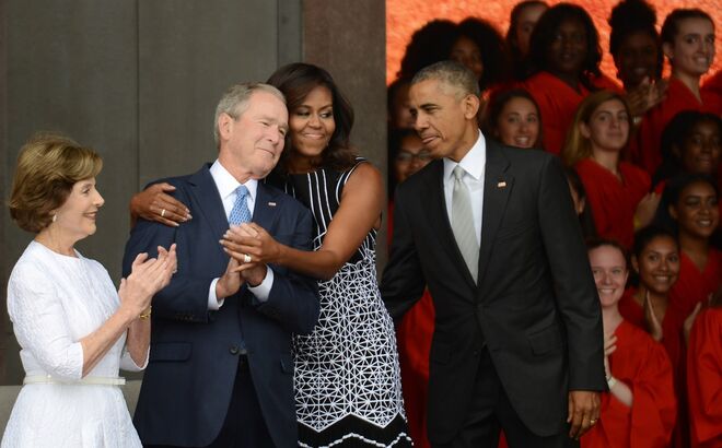 George W. Bush e Michelle Obama | Mas aquela não foi a primeira nem última vez que os dois protagonizaram momentos insólitos. Nesta imagem, podemos ver Michelle abraçar George W. Bush durante a inauguração de um museu afro-americano. E a julgar pela cara do ex-Presidente, parece que gostou.
