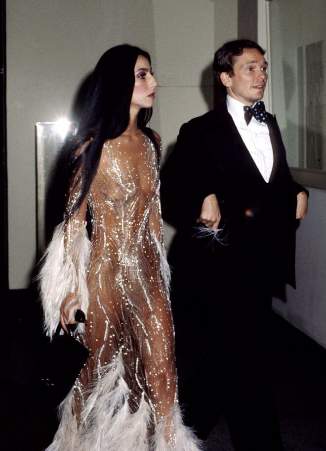 CHER | A cantora usou vários looks inesquecíveis, mas um deles foi criado pelo colaborador habitual Bob Mackie, em 1974. O vestido transparente apareceu mais tarde na capa da revista Time, provocando uma enchente de chamadas que pediam modelos iguais ao de Mackie.