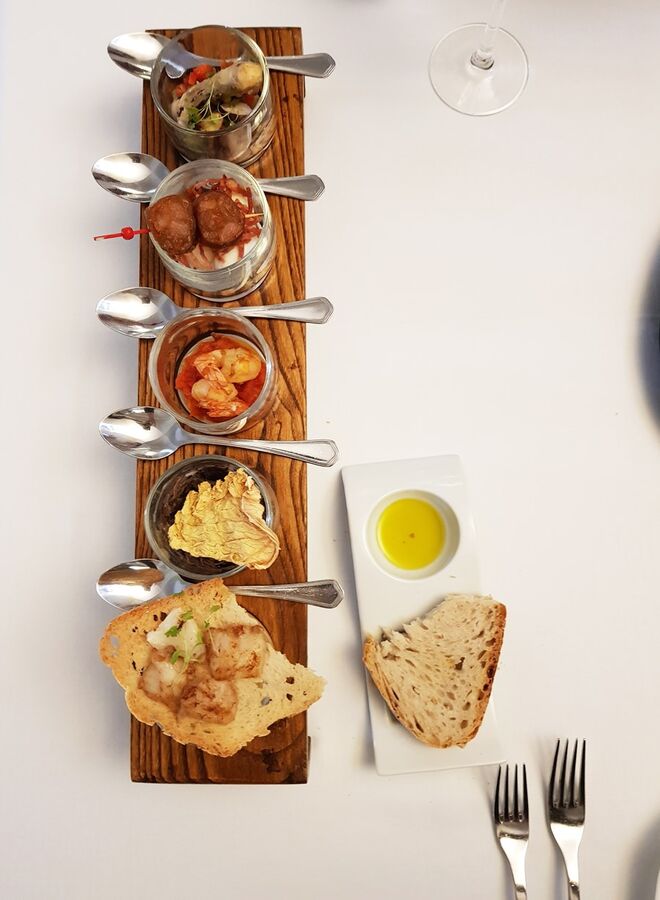 Restaurante Divinus: entradas compostas por creme de grão com bacalhau confitado em tosta, saladinha de lebre com lombardo desidratado, escabeche de polvo, saladinha de ovo de codorniz e enchidos de farinheira no espeto e camarão salteado com compota de tomate (€19)