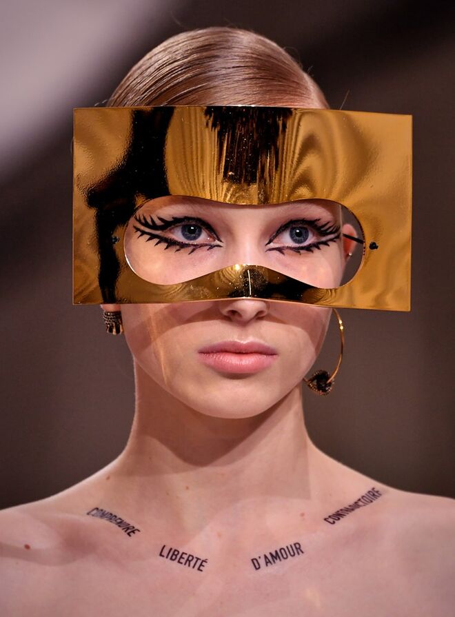 Desfile alta-costura primavera/verão 2018 Dior: As máscaras foram outro dos destaques da beleza do desfile e as atenções centraram-se nos olhos, com um delineador gráfico bem marcado. Na pele, Philips usou a base de alta cobertura Diorskin Forever Undercover.