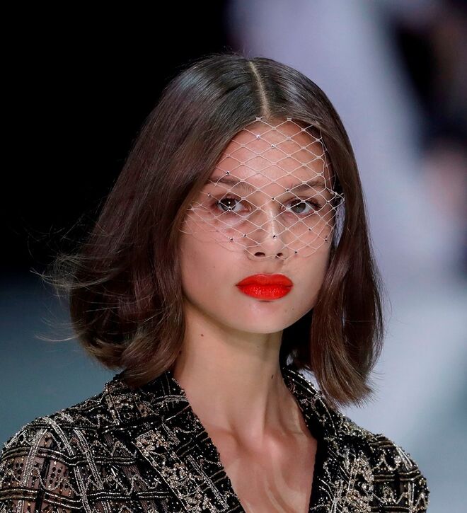Desfile alta-costura primavera/verão 2018 Ralph & Russo: O batom vermelho foi o protagonista da maquilhagem. O voillet foi o acessório que acompanhou os cabelos simplesmente escovados e divididos ao meio.