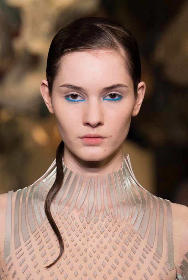 Desfile alta-costura primavera/verão 2018 Iris van Herpen: A paleta de cores naturais em tons verdes, amarelos, azuis e púrpura borrados e desbotados das roupas foi transmitida para a maquilhagem.