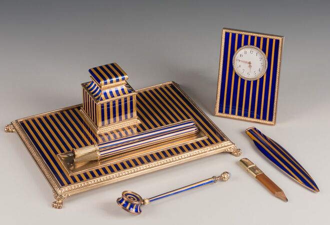 Conjunto de escrita, lápis numa caixa, relógio de secretária, em ouro, prata e esmalte com as cores que a família Rothschild usava nas corridas de cavalos (azul escuro e amarelo). Pelos mestres artesãos da Fabergé Henrik Wigström e Vasili Soloviev. São Petersburgo, 1908/17. Fabergé: Theasures of Imperial Russia, Rizzoli.