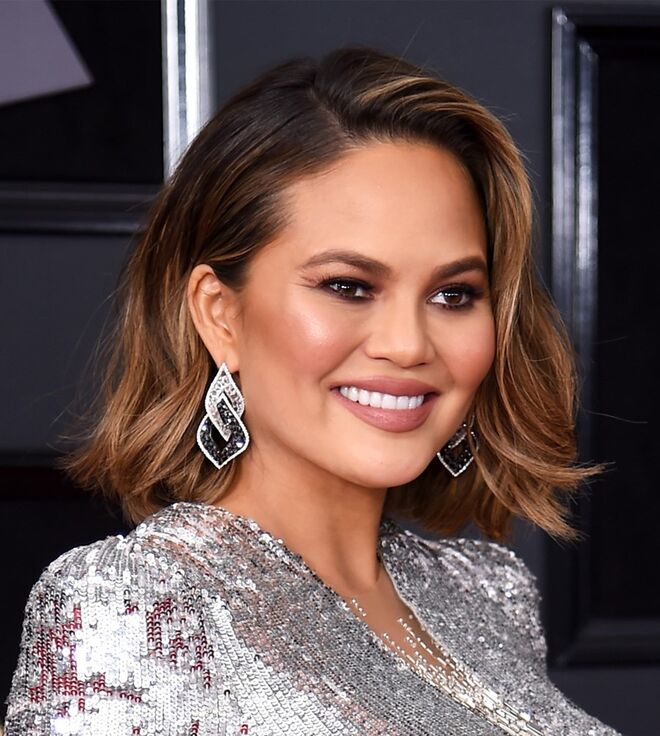 Chrissy Teigen | Mary Phillips usou produtos La Mer para a maquilhagem de Chrissy, os iluminadores da Becca Cosmetics nos tons Rose Gold e Beach Nectar (que fazem parte da paleta BECCA x Chrissy Teigen Glow Face) e nos lábios o Cream Lip + Cheek Pencil no tom Mystic da Nudestix. A hairstylist Jen Atkin foi responsável pelo cabelo.