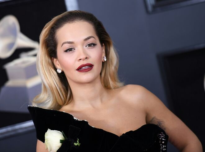 Rita Ora | O hairstylist Brent Lawler penteou o cabelo da cantora para trás, o que destacou o seu rosto. A maquilhagem de Kathy Jeung apostou nos lábios, com o batom vinho Stay Matte Liquid Lip Colour no tom 810 Plum This Show, da Rimmel. Nos olhos, usou a paleta de sombras Magnif’Eyes Blush Edition, também da Rimmel.