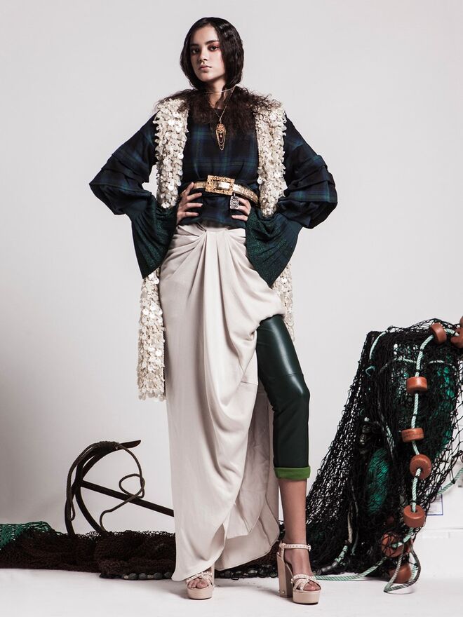 Junto à barra | Stylist: Rita Paupério da Silva e Modelo: Carolina Graça (Face Models) | Colete e vestido, da produção. Camisola xadrez, da Top Queens. Camisola verde com mangas largas, Uterqüe; Calças, Cortefiel. Colar e cinto, da produção; Sandálias, Mango.