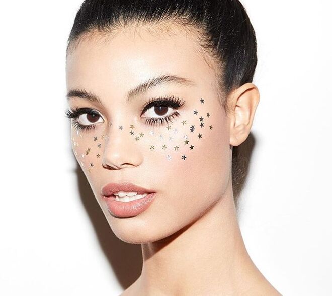 Estrelas pequenas e brilhantes coladas na zona das maçãs do rosto. O gel de cabelo também é uma boa opção para fixar.