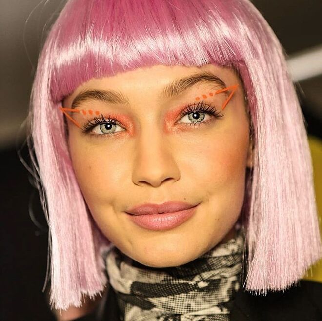 Jeremy Scott (08/02/2018): A beleza foi criada com a linha que o próprio estilista fez em colaboração com a M.A.C. O eyeliner em 3D foi o produto-estrela. Os cabelos, pensados por Eugene Souleiman, foram escondidos com perucas de comprimento curto, franjas e cores fortes. Do roxo-techno ao verde-ácido, ao rosa-bebé, ao laranja-elétrico e ao azul-cerúleo, foram vários os tons garridos em destaque.