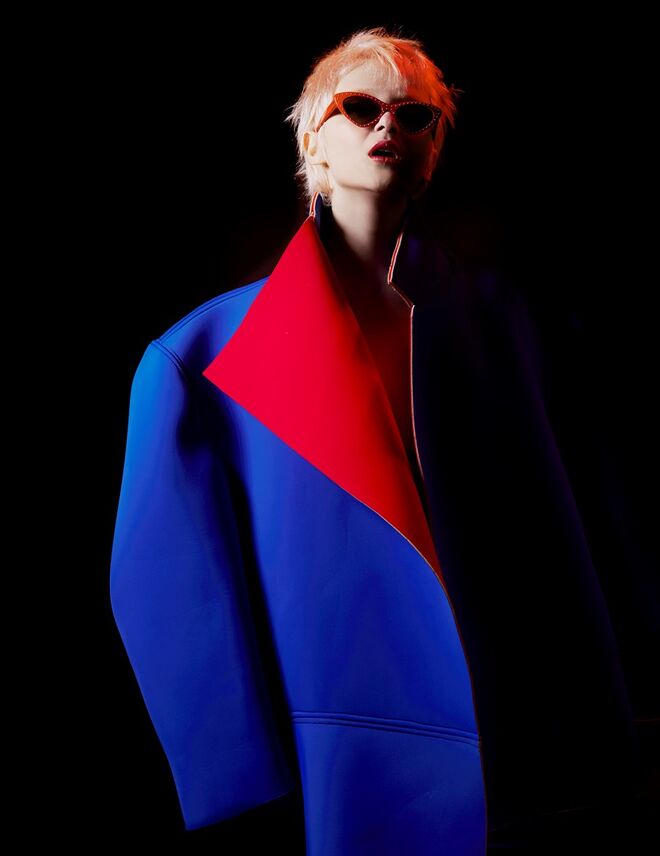 Casaco em neopreno, Gonçalo Peixoto. Óculos em acetato com tachas, Moschino.