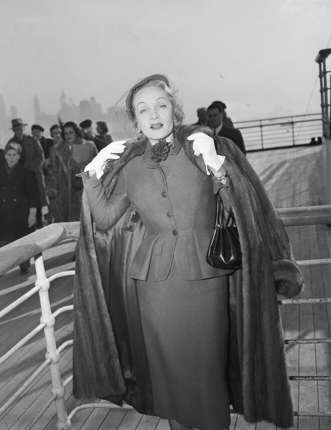 Marlene Dietrich com um tailleur Christian Dior a bordo do Queen Elizabeth, a chegar a Nova Iorque a 21 de dezembro de 1950. Exposição Ocean Liners: Speed and Style no Victoria & Albert Museum, em Londres
