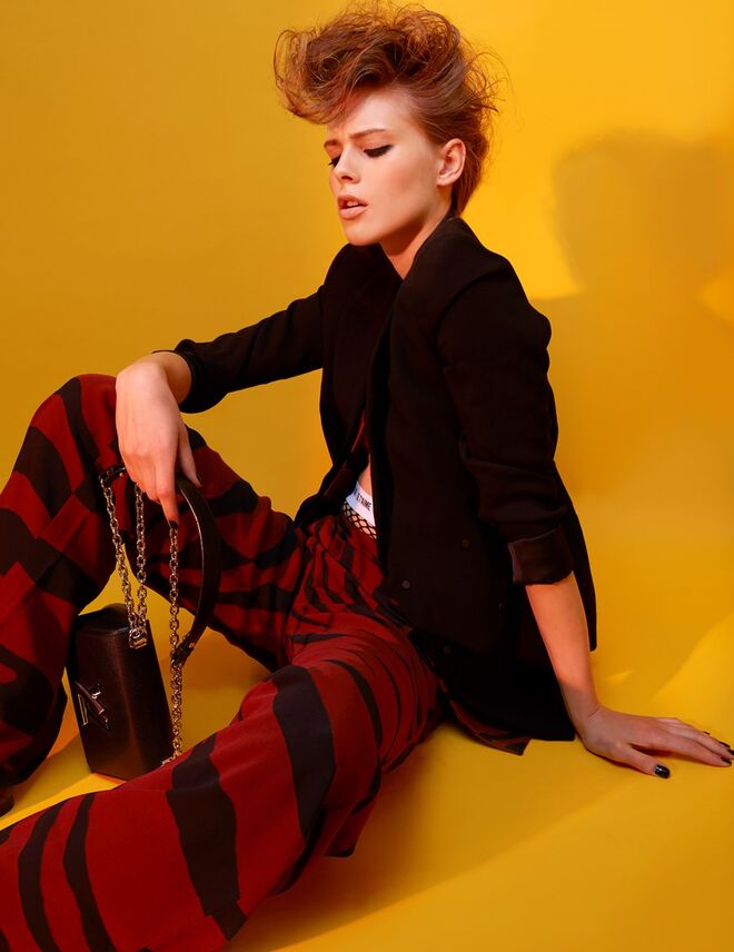 Blazer em viscose, Mango. Colete e calças em viscose, Roberto Cavalli. Carteira em pele e metal, Louis Vuitton. Collants em rede, Calzedonia.