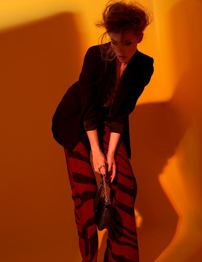 Blazer em viscose, Mango. Colete e calças em viscose, Roberto Cavalli. Carteira em pele e metal, Louis Vuitton. Collants em rede, Calzedonia.