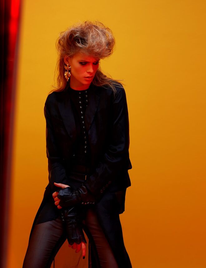 Casaco e calças em musselina de seda e body em viscose, Max Mara. Colete/espartilho em algodão e luvas em pele, Elisabetta Franchi. Brincos em latão banhado a ouro, Carolina Curado. 