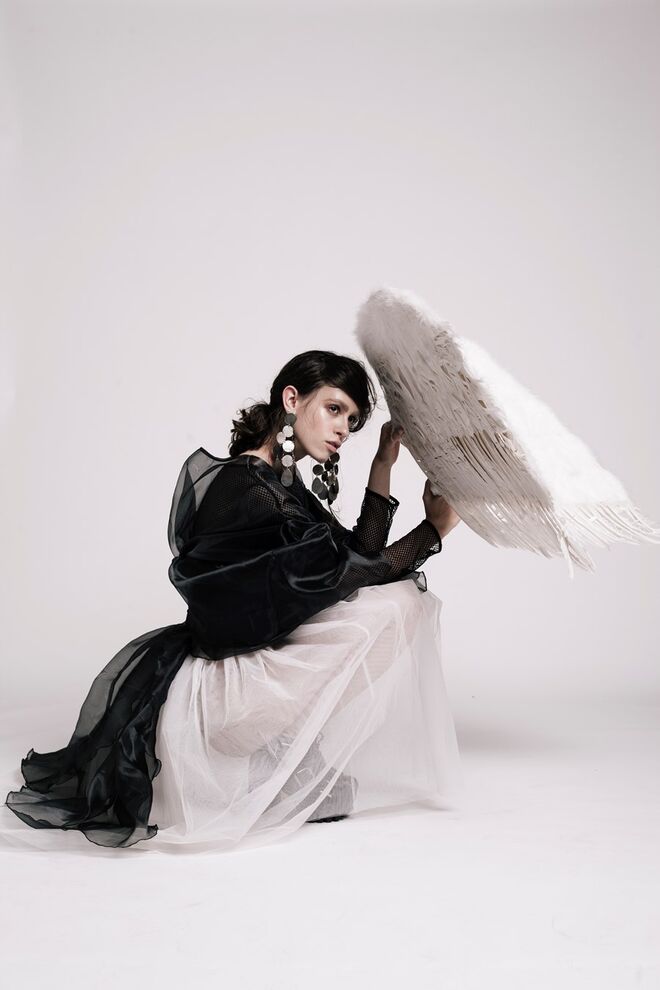 “The Bad Angel” |  Stylist: Nina Tamisa | Modelo: Catarina Silva – Face Models. Saia de tule e capa preta, Peris; corpete e top de rede, da produção; botas e brincos, da produção; asas, Peris.