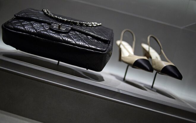 A carteira matelassé com as alças em forma de corrente para colocar ao ombro e  os sapatos bicolores (normalmente beijes e com as pontas pretas) são algumas das criações de Gabrielle Chanel que perduram e que são adaptadas, ainda hoje, em múltiplas coleções de outras marcas. Exposição no Palais Galliera, em Paris, a 10 de julho de 2014