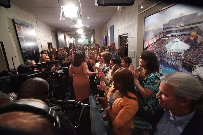 2011. A equipa de produção dos Harpo Studios cumprimenta Oprah Winfrey nos bastidores depois do último episódio do The Oprah Winfrey Show.
