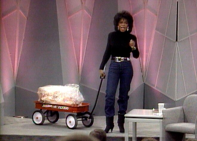 1988. Oprah Winfrey puxa um carrinho com os cerca de 30 quilos que a apresentadora perdeu numa dieta de líquidos. 