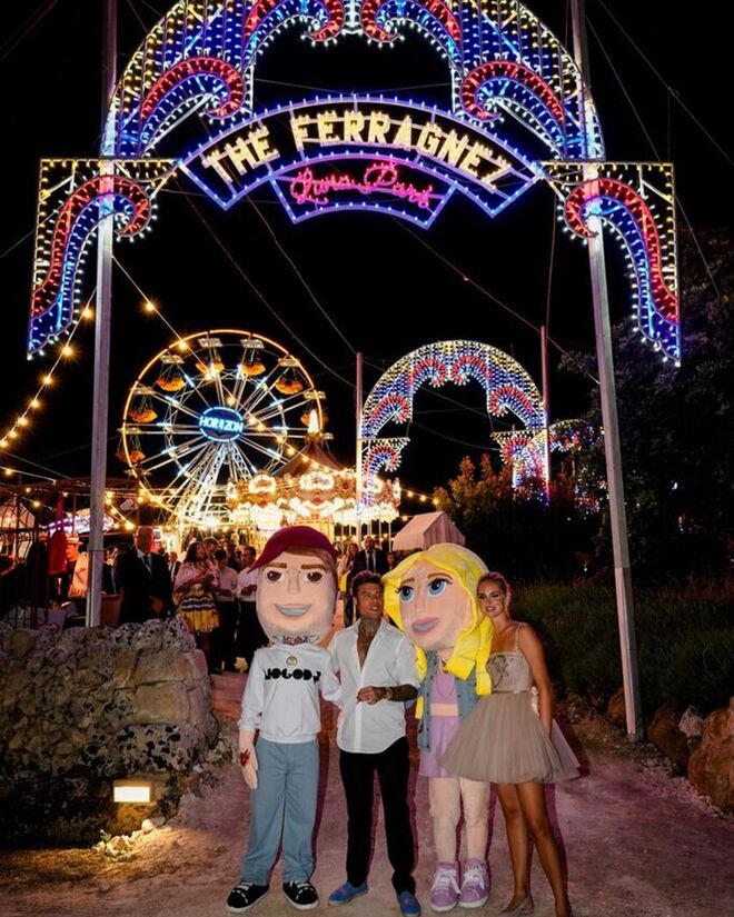 O casal e os mascotes no parque de diversões do casamento