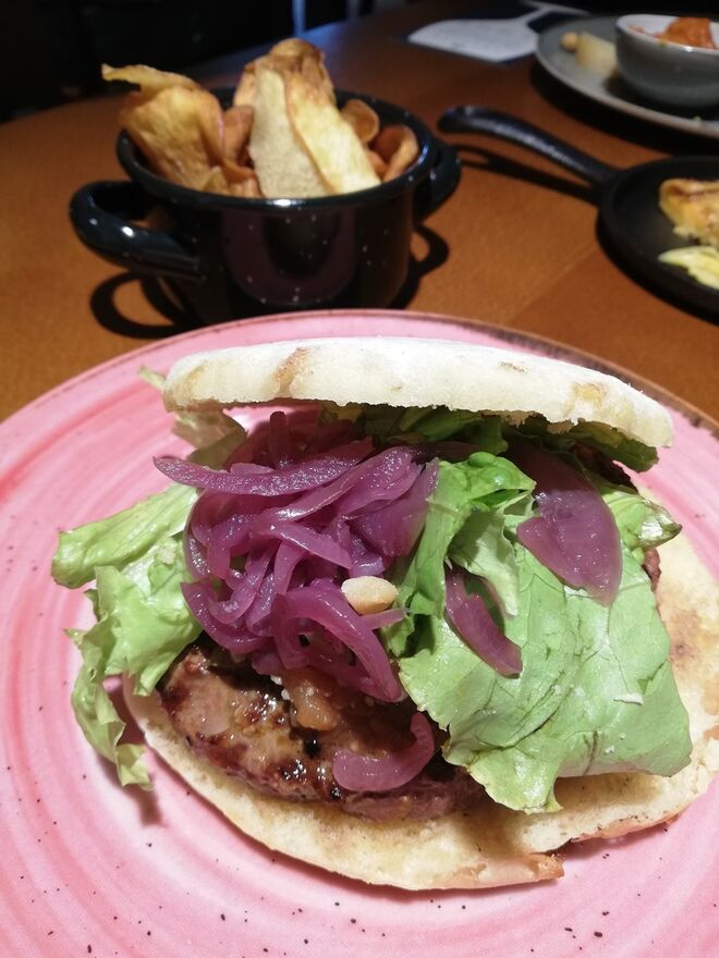 Da Egitânia aos Açores, hambúrger de vaca bio em bolo Lêvedo, relish de tomate especiado, malagueta, lima, aros de cebola de curtume, queijo picante velho, rúcula, agrião e alfaces