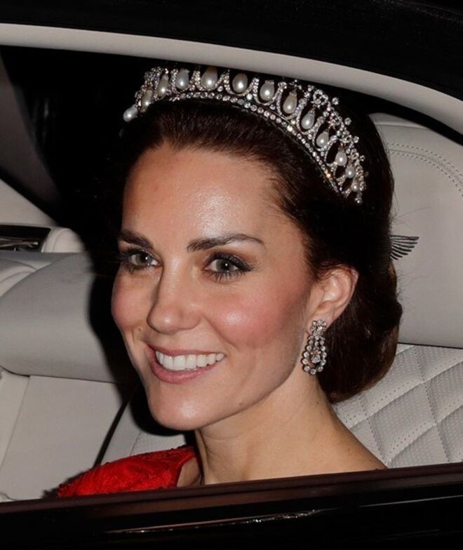 A Duquesa de Cambridge com a Tiara dos Amantes de Cambridge. Kate foi vista com a tiara pela primeira vez em 2015, na Annual Diplomatic Reception, e é a sua tiara de eleição desde então. Tem 19 pérolas abraçadas por arcos de diamantes.