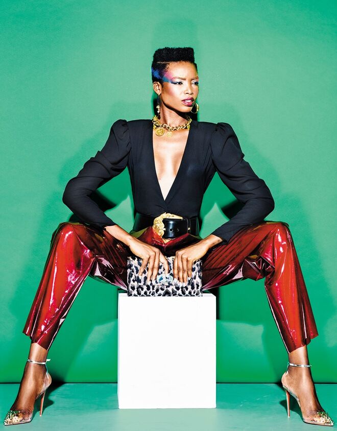 Blusa em crepe de seda, Miguel Vieira. Calças em PVC, Luís Carvalho. Brincos em ródio com cristais, Swarovski. Colar em metal e cinto em pele, Versace. Clutch em algodão e lurex e sandálias em PVC e metal, Christian Louboutin