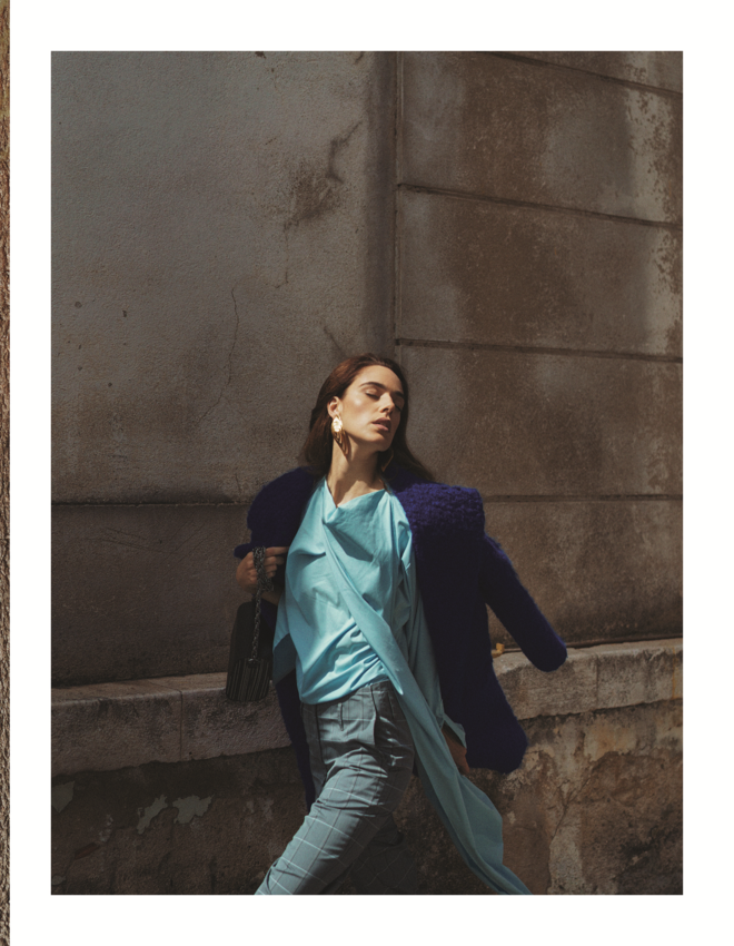 Na linha da frente | Catarina Santos: casaco em lã, Carlos Gil. Blusa em popelina de algodão e calças em lã, Pedro Pedro. Brincos em prata dourada, Vanglória. Carteira em madeira, Marita Morena. 
