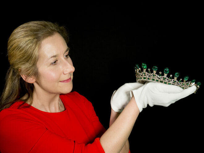Uma conservadora dos Historic Royal Palaces a preparar a tiara de esmeraldas e diamantes na exposição Victoria Revealed, Palácio de Kensington.
