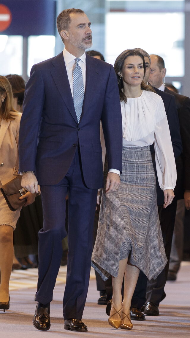 A rainha levou uma saia midi aos quadrados, da marca Massimo Dutti com uma camisa branca plissada e uns saltos Magrit, na sua visita à inaguração da Fitur 2019. 