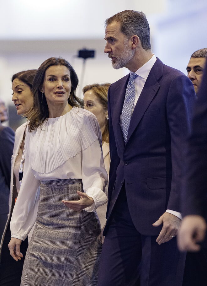 A rainha levou uma saia midi aos quadrados, da marca Massimo Dutti com uma camisa branca plissada e uns saltos Magrit, na sua visita à inaguração da Fitur 2019. 
