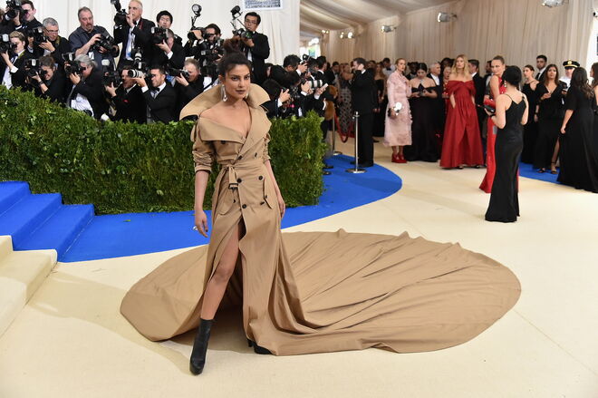 Priyanka Chopra, 2017 | Priyanka brilhou na MET Gala de 2017 com um trench coat. Sim, uma gabardine. Da autoria de Ralph Lauren, a atual mulher de Nick Jonas apareceu incrivelmente elegante com uma gabardine/vestido no tom camel que deixou os críticos da moda de opinião dividida. 